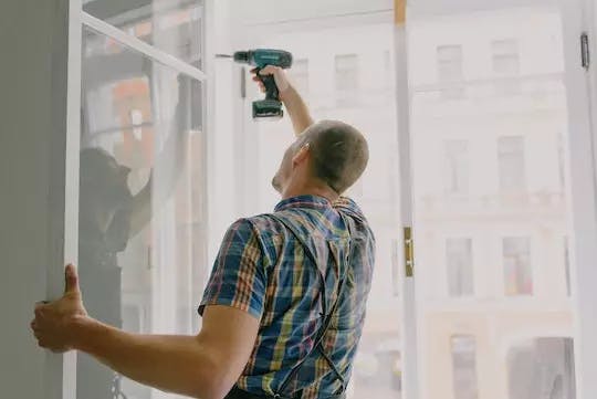 Handyman fixing a window for a house